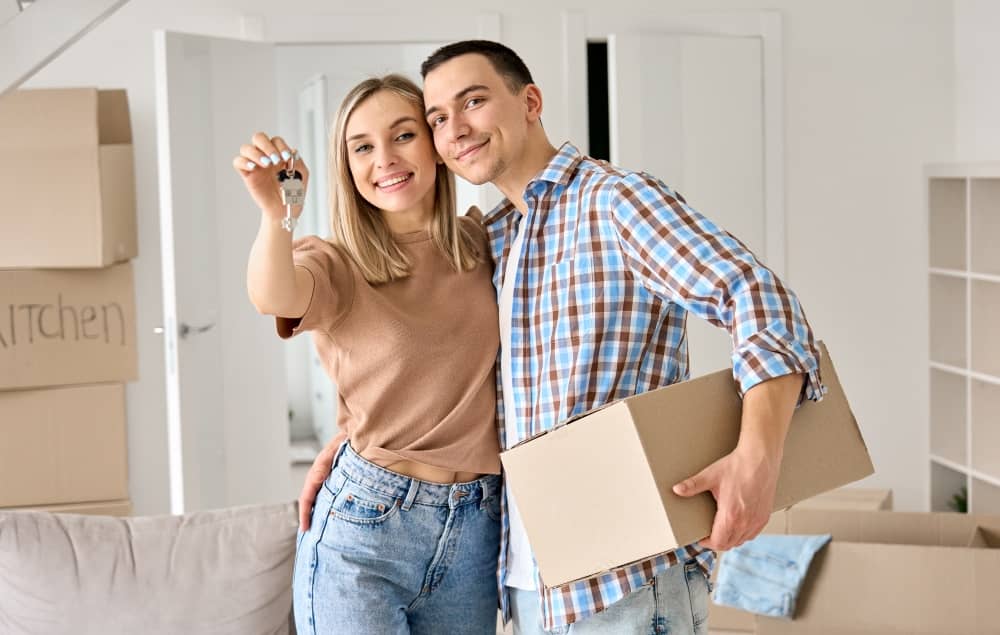 Happy couple showing keys to their new home.